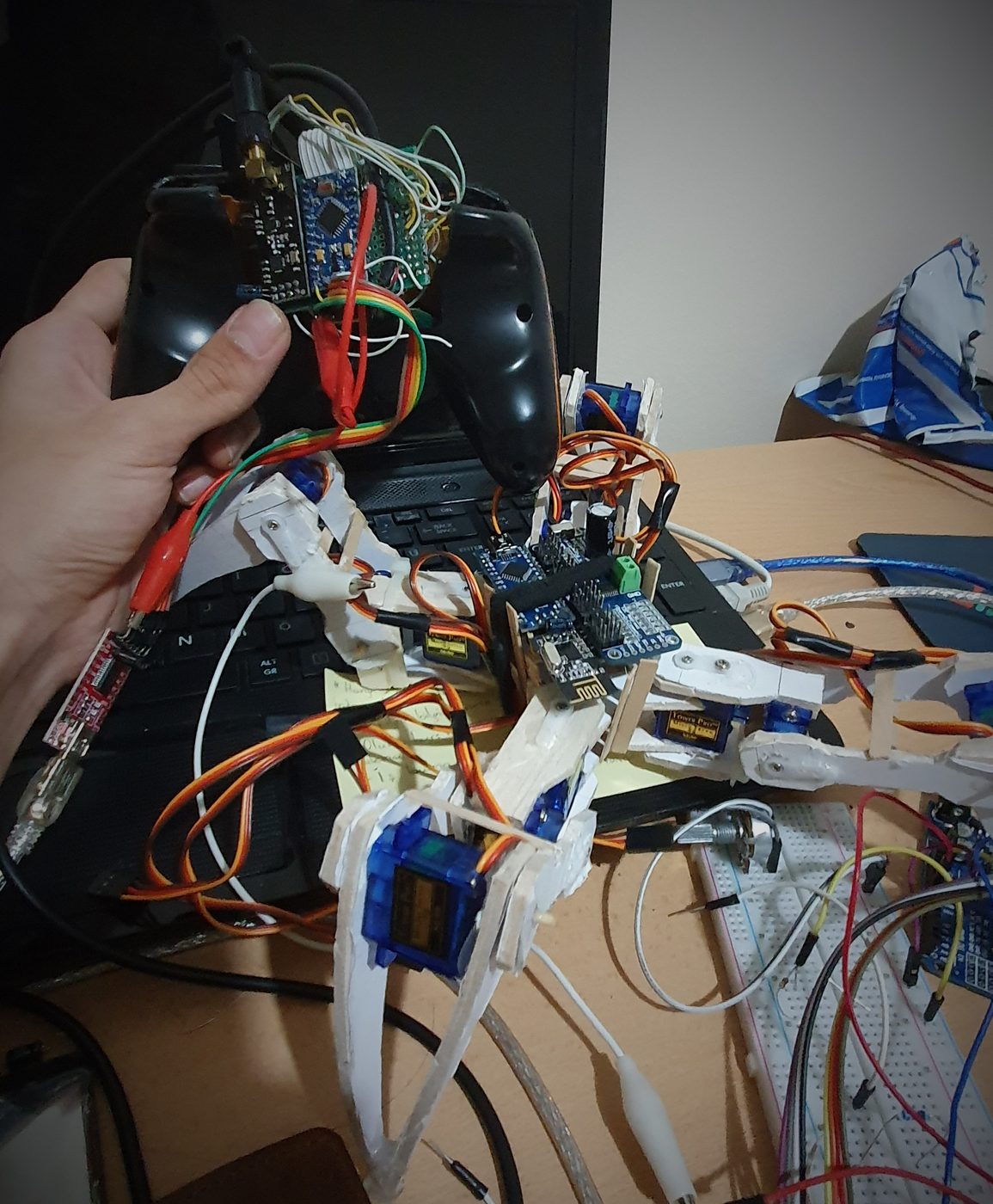 The V1 quadruped robot on a desk, wired to its RC receiver and servo driver