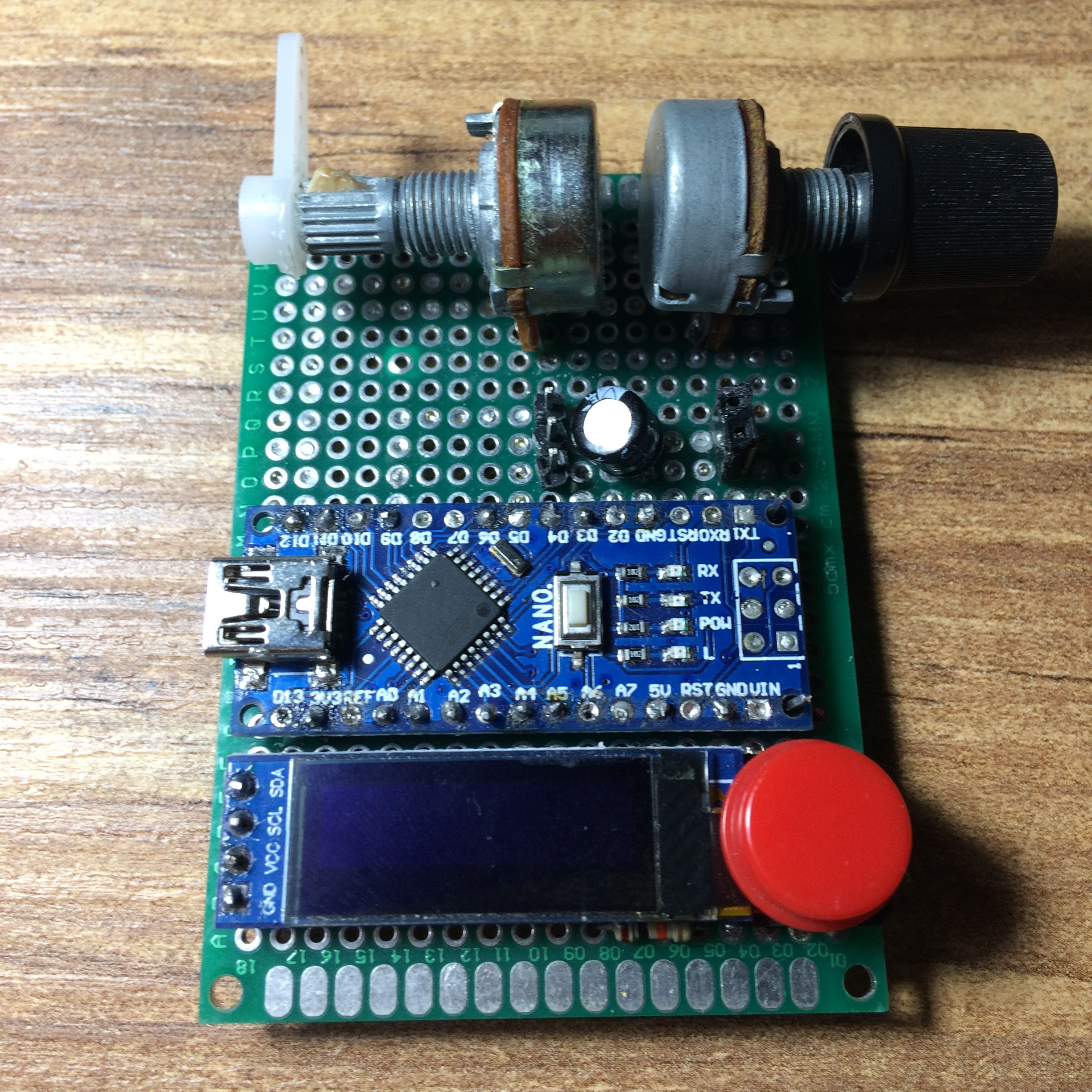 Close-up of the assembled servo tester: Arduino Nano, OLED display, two potentiometers, and a push button on protoboard